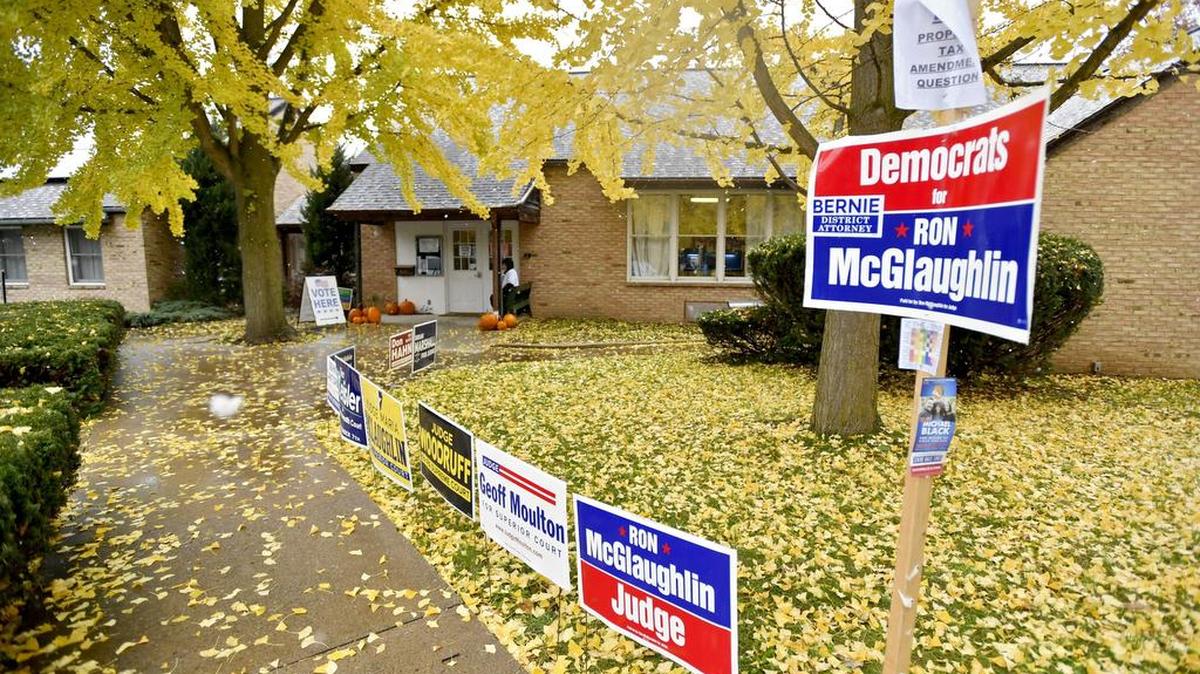 Fall leaves and snow fall outside a voting location at the Friends Meeting House on Tuesday.