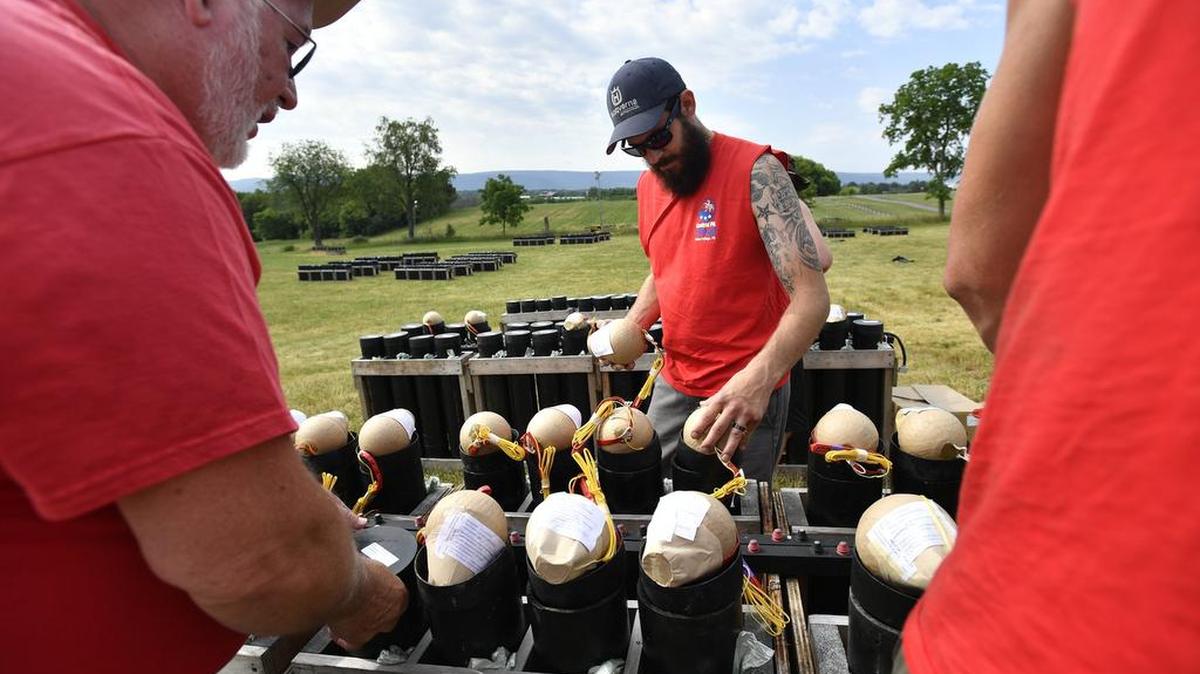 Ron Williams, center, fills tubes with five-inch shells. Volunteers are preparing the fireworks for the Central Pennsylvania 4th Fest.