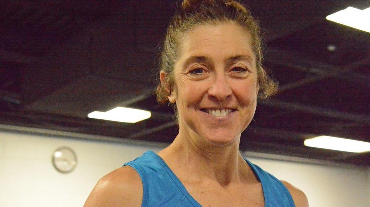 Deborah Battaglia poses for a photo on Tuesday at the YMCA in State College. She’s completing 50 full distance (Ironman) triathlons this year.