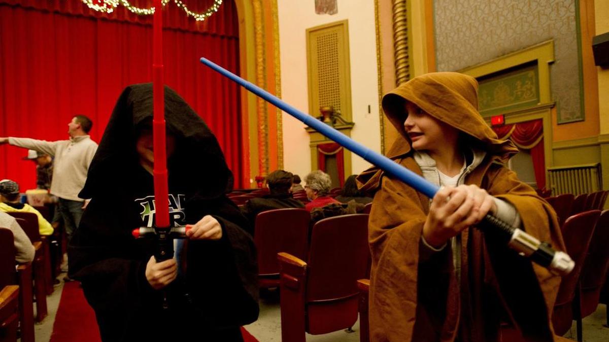 Cousins Talon Koptchak, 7, and Dylan Koptchak, 8, play with their light sabers before the newest “Star Wars: The Force Awakens,” Thursday night at the Rowland Theatre.