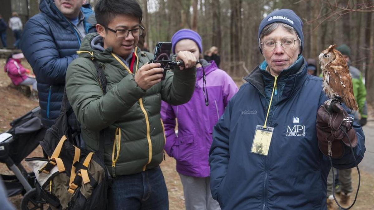 Volunteer Joanne Hughes, right, holds an eastern screech owl for attendees to see during the Maple Harvest Festival on Sunday at Shaver’s Creek Environmental Center.