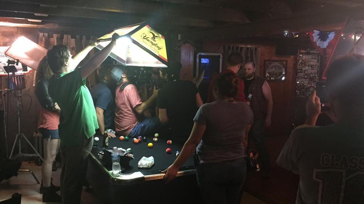Ted Rosenblum, of State College, holds a prop light before a take from the upcoming movie “Generational Sins.” The actors, camera operator and director stand on the right. Rosenblum worked as a production assistant and an extra during a shoot Aug. 12 at JC’s Bar and Grill in Morrisdale.