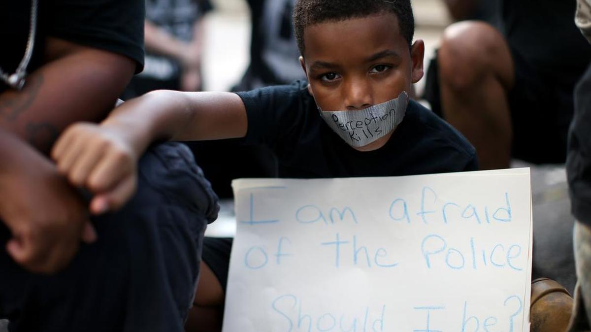 A young boy holds his fist up while wearing tape over his mouth during a Black Lives Matter protest in Atlanta on Saturday in response to the police shooting deaths of Terence Crutcher in Tulsa, Okla., and Keith Lamont Scott in Charlotte, N.C.