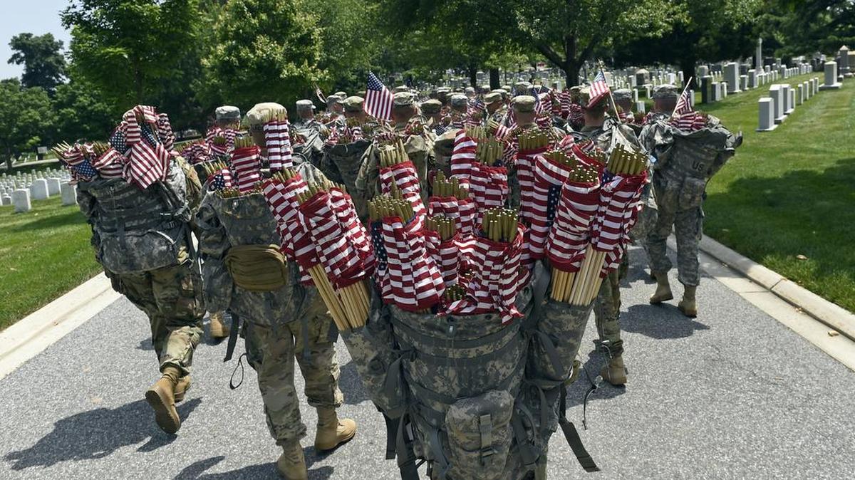 Members of the Old Guard prepare to place flags in front of every headstone at Arlington National Cemetery in Arlington, Va., on Thursday. Soldiers were to place nearly a quarter of a million U.S. flags at the cemetery as part of a Memorial Day tradition.