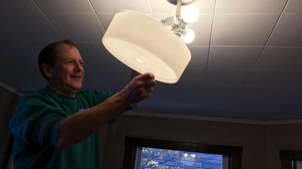 The Rev. Dean Lindsey, senior pastor at State College Presbyterian Church, installs a new light Friday at the Stormbreak shelter.