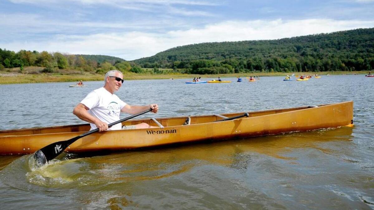 President Judge Thomas King Kistler paddles through the water during the boat float at the Save Colyer Lake fundraiser in 2013.