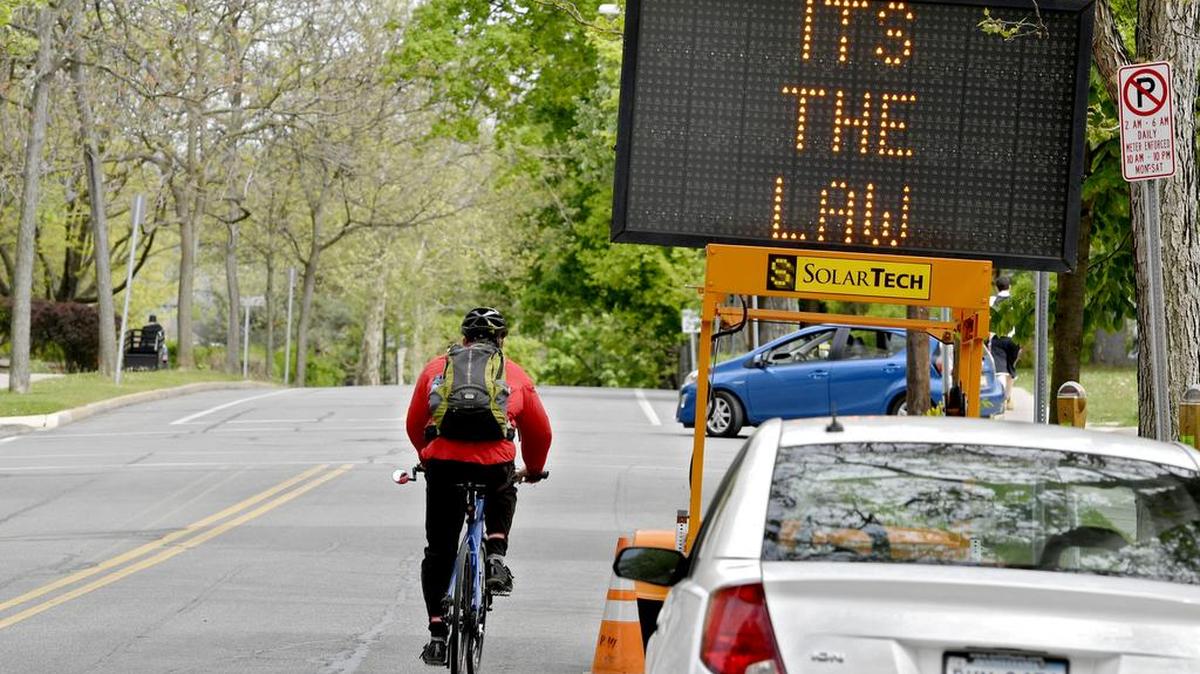 A cyclist rides down Allen Street in State College on Tuesday as an electronic sign reminds drivers that “it’s the law” to give bicyclists 4 feet of space. County Board of Commissioners Vice Chairman Mark Higgins declared the month of May as National Bike Month in Centre County.