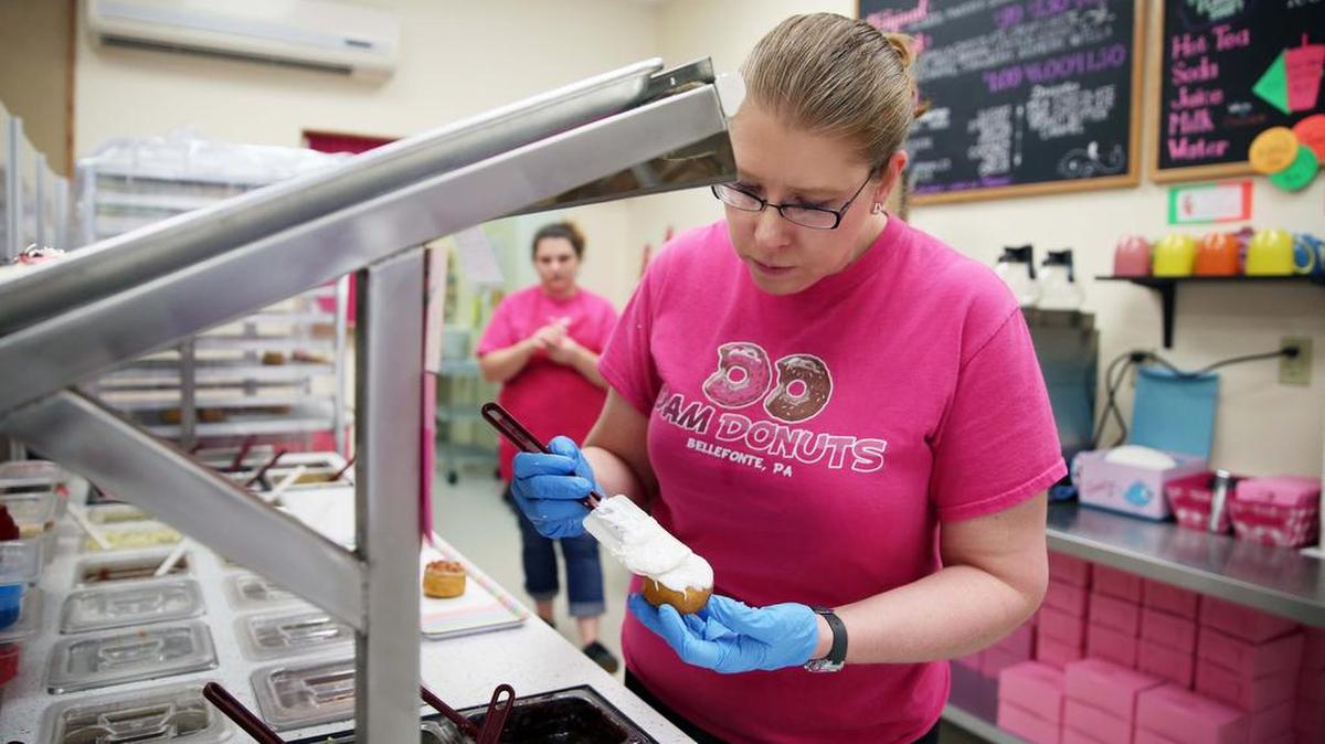 Owner Traci Beck prepares donuts Tuesday, April 25, 2017 at Dam Donuts in Bellefonte.