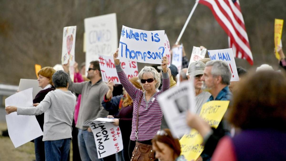 Terry Melton holds up a sign as constituents gather outside of U.S. Rep. Glenn Thompson’s Bellefonte office on Benner Pike on Thursday.