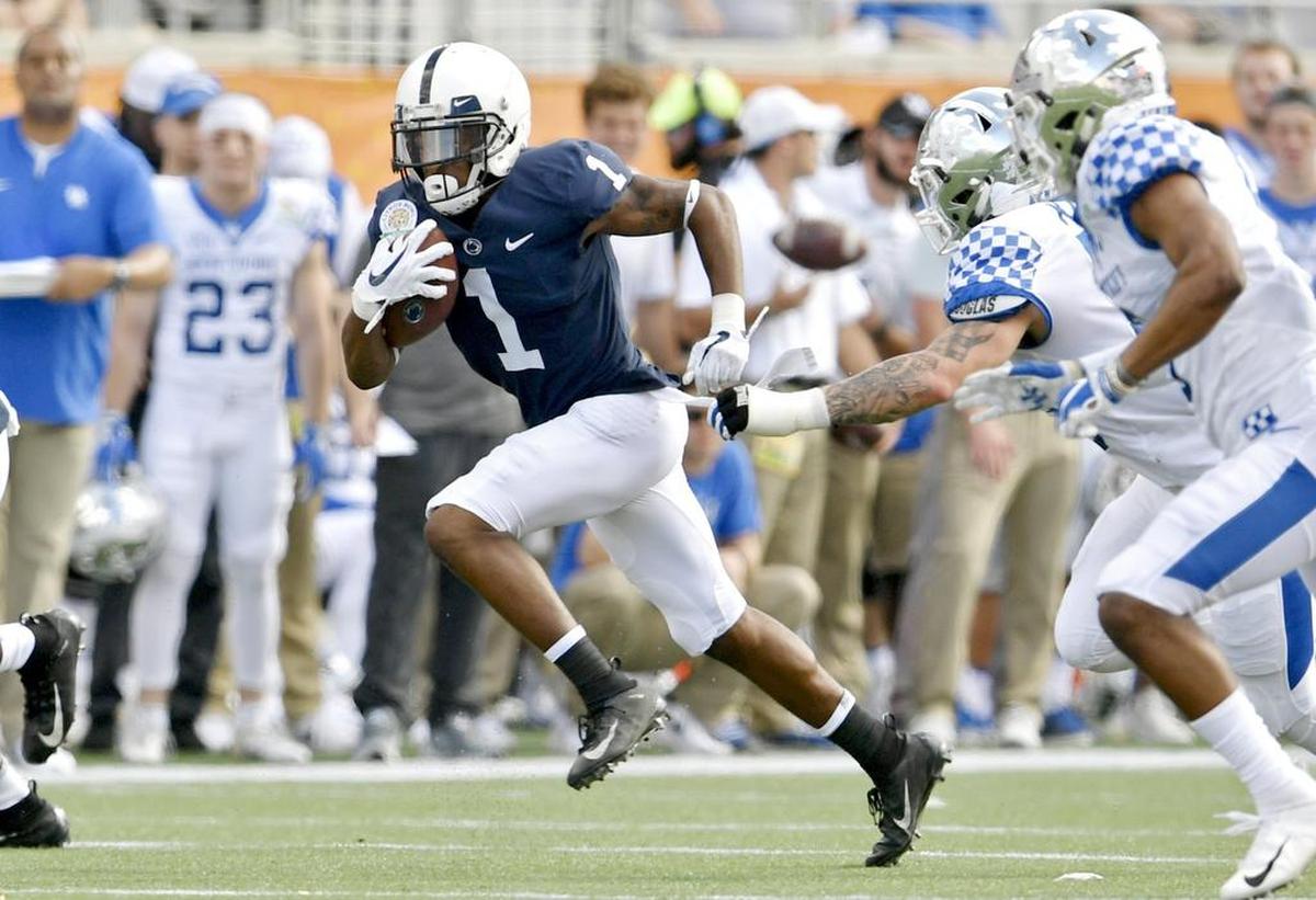 Penn State wide receiver KJ Hamler runs from Kentucky defenders during the Citrus bowl on Tuesday, Jan. 1, 2019 at Camping World Stadium.