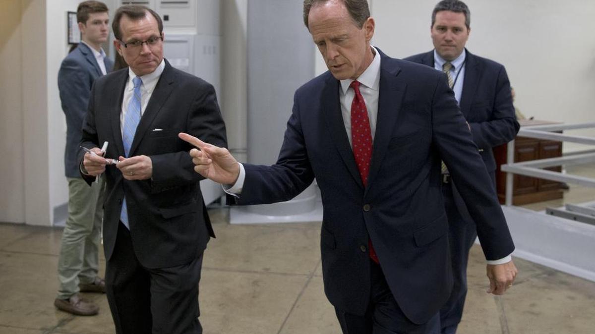 Sen. Patrick Toomey, R-Pa., center, walks towards the Senate on Capitol Hill Monday in Washington. A divided Senate hurtled Monday toward an election-year stalemate over curbing guns, eight days after Orlando’s mass shooting horror intensified pressure on lawmakers to act but left them gridlocked anyway, even over restricting firearms for terrorists.