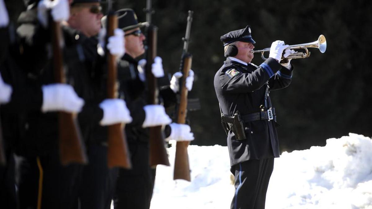 State College police Officer David White plays taps after the honor guard gives a 21-gun salute during funeral services for State College police Officer Bob Bradley in February 2015.