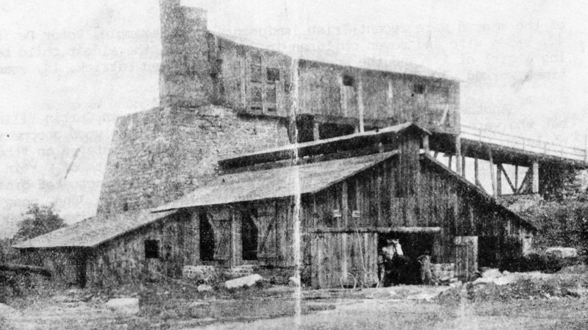The stack and the stackhouse, from which iron ore and fuel were fed into the furnace, can be seen as they appeared during operation at the Curtin Ironworks in this photo dating to before 1872.
