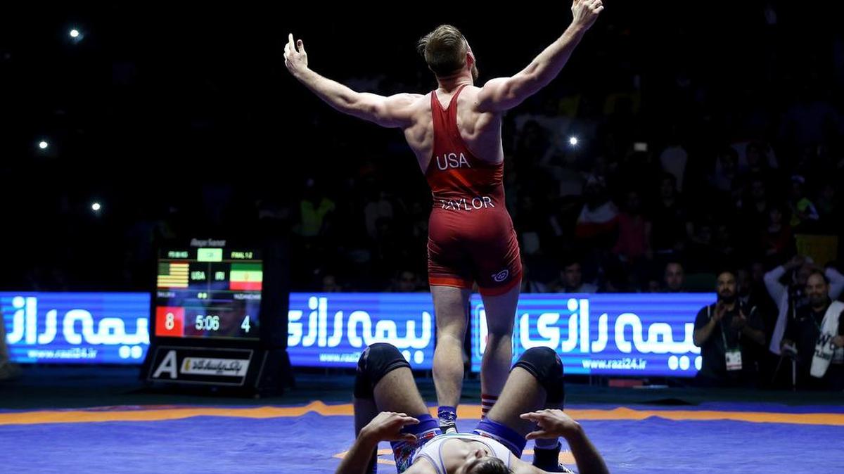 In this photo released by the Iran Newspaper, United States' wrestler David Taylor, standing, celebrates after defeating Iran's wrestler Hassan Yazdani during the men's freestyle 86 freestyle wrestling competition at the 2017 world cup final match in Kermanshah, Iran, Friday, Feb. 17, 2017. Iran's wrestling team has defeated the United States wrestling team to win gold medal in the Freestyle World Cup. (Naeim Ahmadi, IIPA via AP)