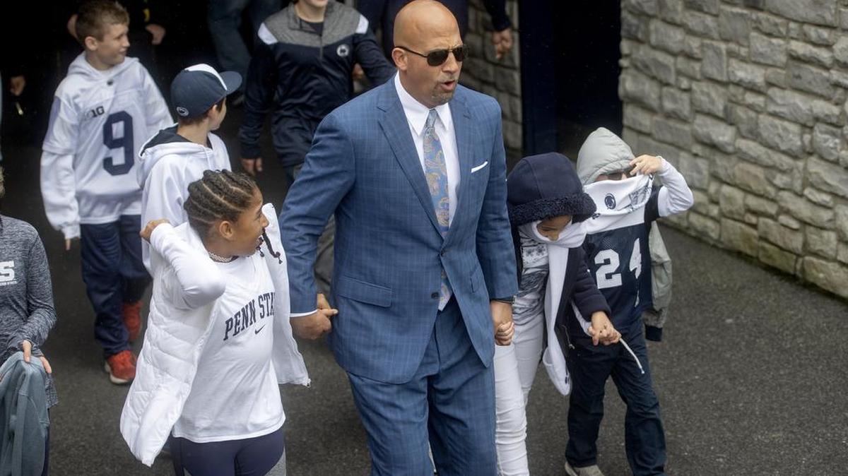 Penn State football coach James Franklin and his daughters react to the chilly rain as they walk through the tunnel and onto the field before the homecoming game against Michigan State on Saturday, Oct. 13, 2018.