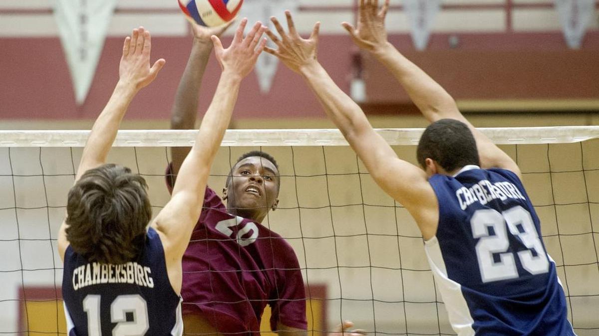 State College’s Jeremy Bullock hits the ball over Chambersburg defenders during Thursday’s game. The Little Lions lost in three sets to the Trojans.