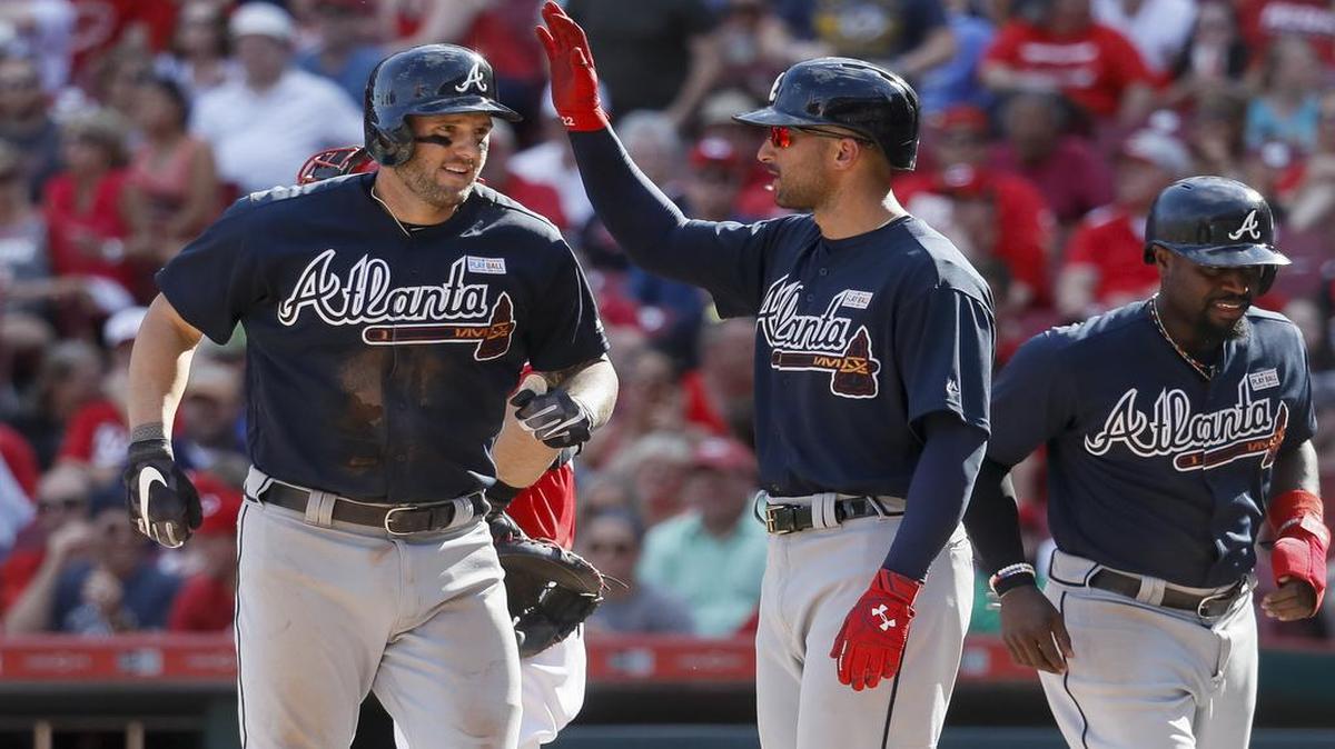 Atlanta Braves' and Philipsburg-Osceola native Matt Adams, left, celebrates with Nick Markakis, center, and Brandon Phillips, right, after hitting a grand slam off Cincinnati Reds starting pitcher Scott Feldman in the fifth inning of a baseball game, Saturday, June 3, 2017, in Cincinnati. (AP Photo/John Minchillo)