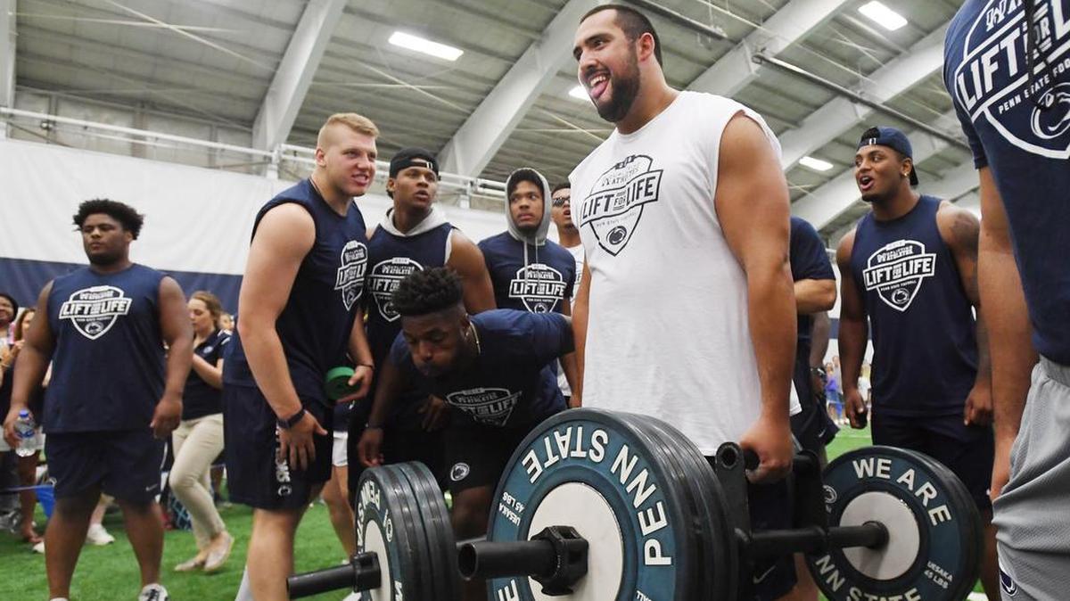 Penn State offensive lineman Steven Gonzalez participates in the farmers hold during Lift for Life Saturday, June 30, 2018 at Holuba Hall.