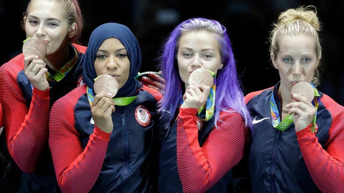From left, Dagmara Wozniak, Ibtihaj Muhammad, Penn State grad Monica Aksamit and Mariel Zagunis, of the United States, kiss the bronze medals they won in a women’s team sabre fencing competition at the 2016 Summer Olympics in Rio de Janeiro, Brazil, on Saturday.