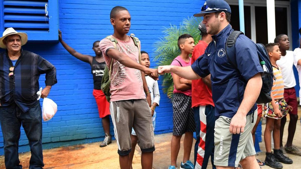Penn State outfielder James Coates is greeted by Cuban youth outside the Latin America Stadium before the team’s game against the Industriales on Monday in Havana, Cuba. The Industriales beat the Nittany Lions 2-1.