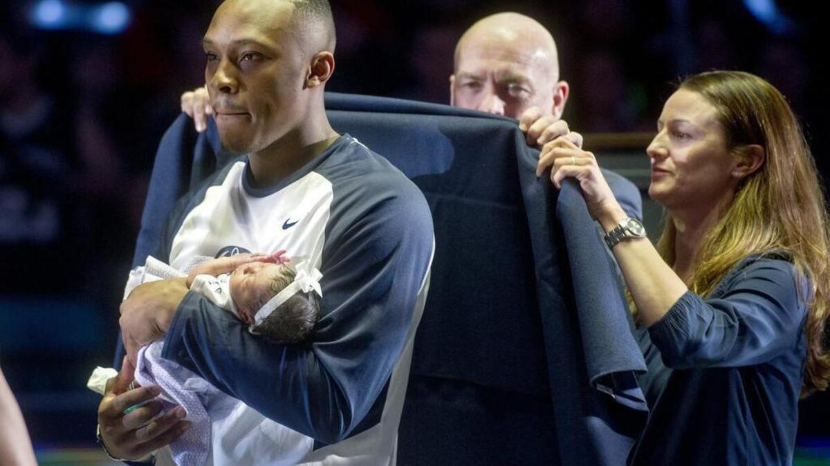 Penn State basketball senior Devin Foster holds his baby Brooklyn as coach Patrick Chambers presents him with his “S” blanket before Thursday’s game.