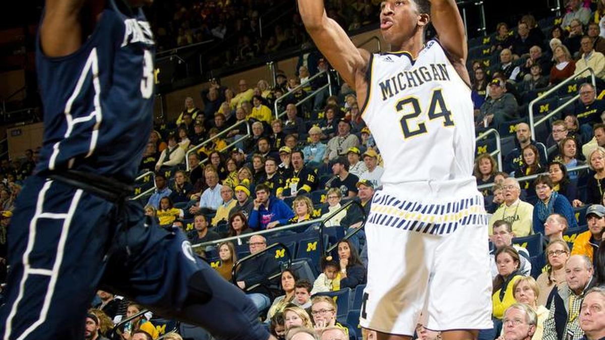 Michigan guard Aubrey Dawkins (24) attempts a 3-point basket as Penn State guard Devin Foster (3) defends during the second half of an NCAA college basketball game at Crisler Center in Ann Arbor, Mich., Saturday, Jan. 2, 2016. Michigan won 79-56.