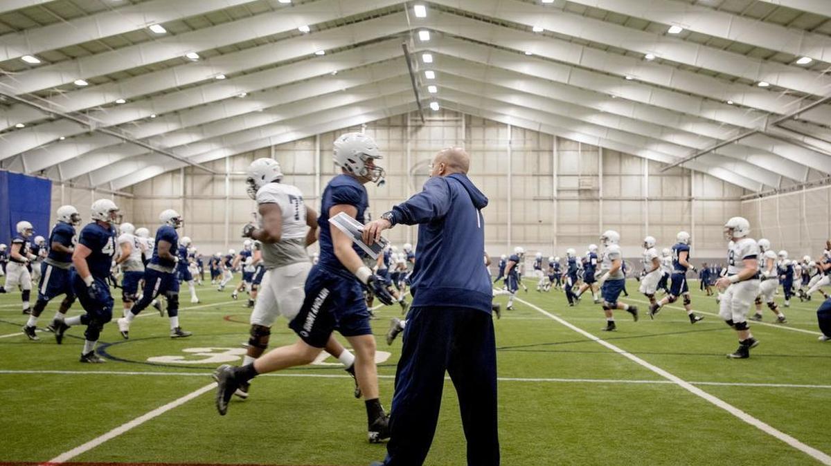 Penn State football coach James Franklin high fives players as the team warms up for practice on Friday, December 18, 2015 at Holuba Hall.