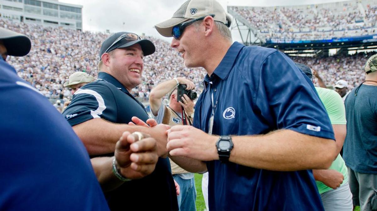 Former Penn State quarterback Kerry Collins hugs teammates from the 1994 Rose Bowl championship team during halftime of a 2014 game. Collins is on the 2018 ballot for the College Football Hall of Fame.
