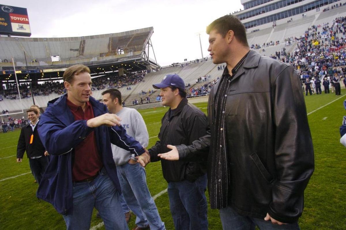 Kerry Collins, left, and Kyle Brady, right, shake hands at halftime of the 2005 Blue-White Game. They were both on the field for Penn State to honor the undefeated 1994 team. Brady was also recently on the field again for the White Out game against Michigan.