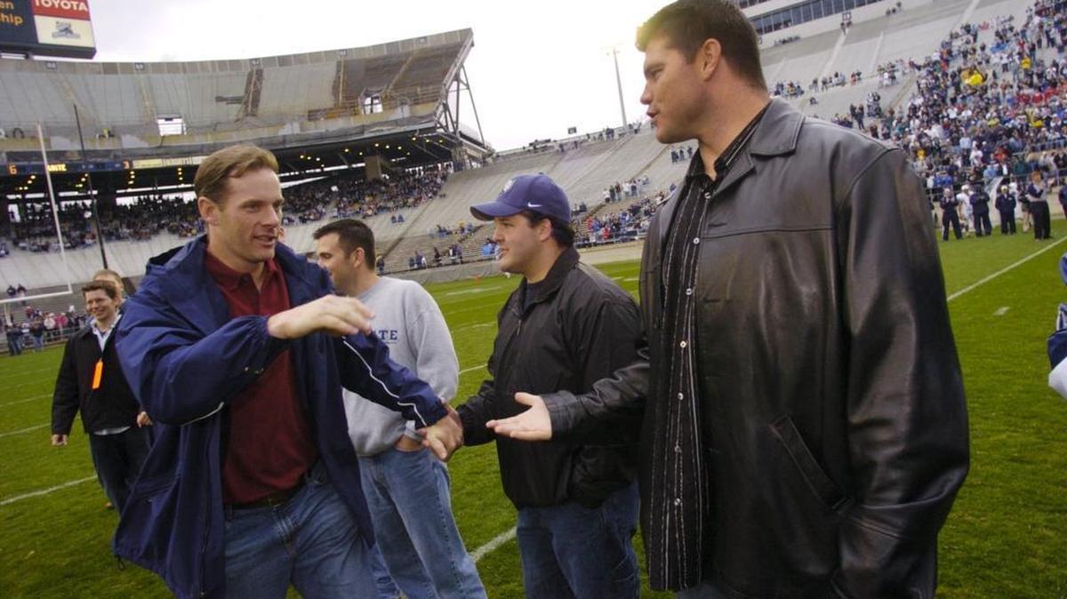 Kerry Collins, left, and Kyle Brady, right, shake hands at halftime of the 2005 Blue-White Game. They were both on the field for Penn State to honor the undefeated 1994 team. Brady was also recently on the field again for the White Out game against Michigan.