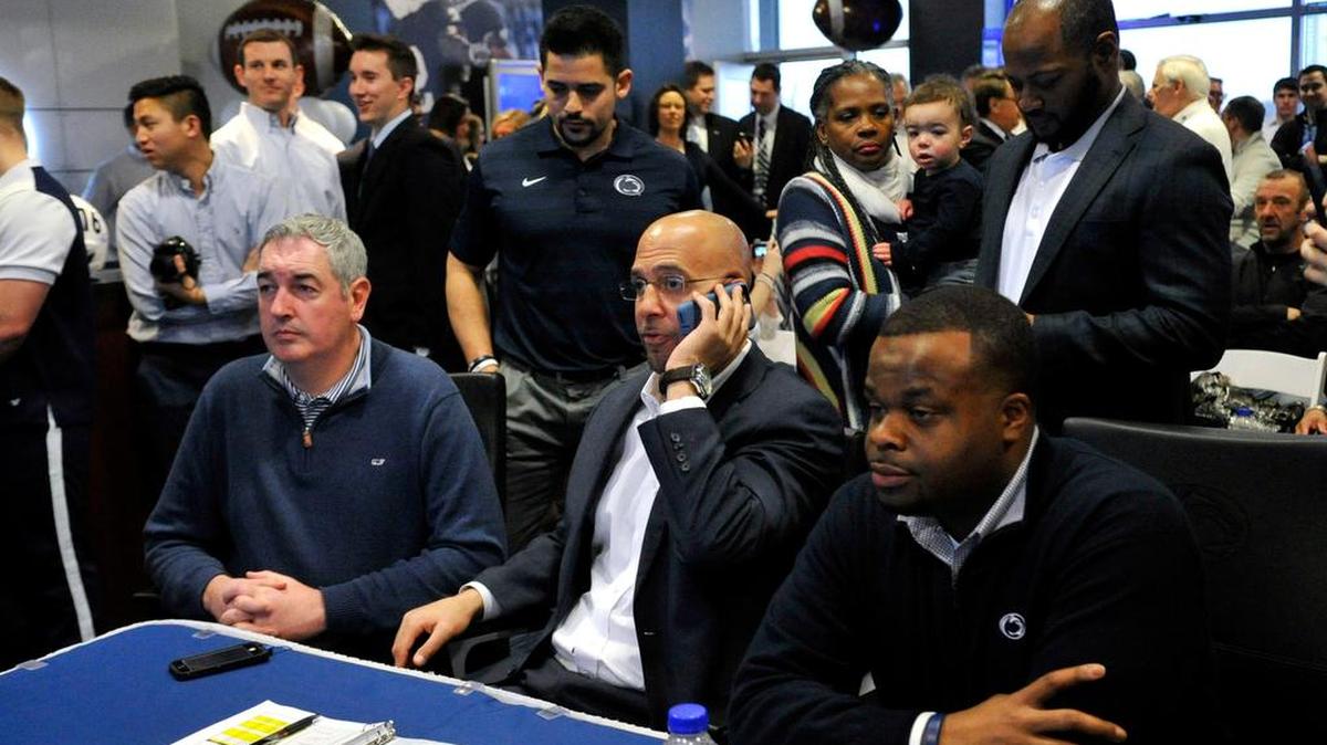 Penn State football head coach James Franklin, center, talks on the phone to a recruit in the "war room" in the Lasch building on campus in University Park, Pa.