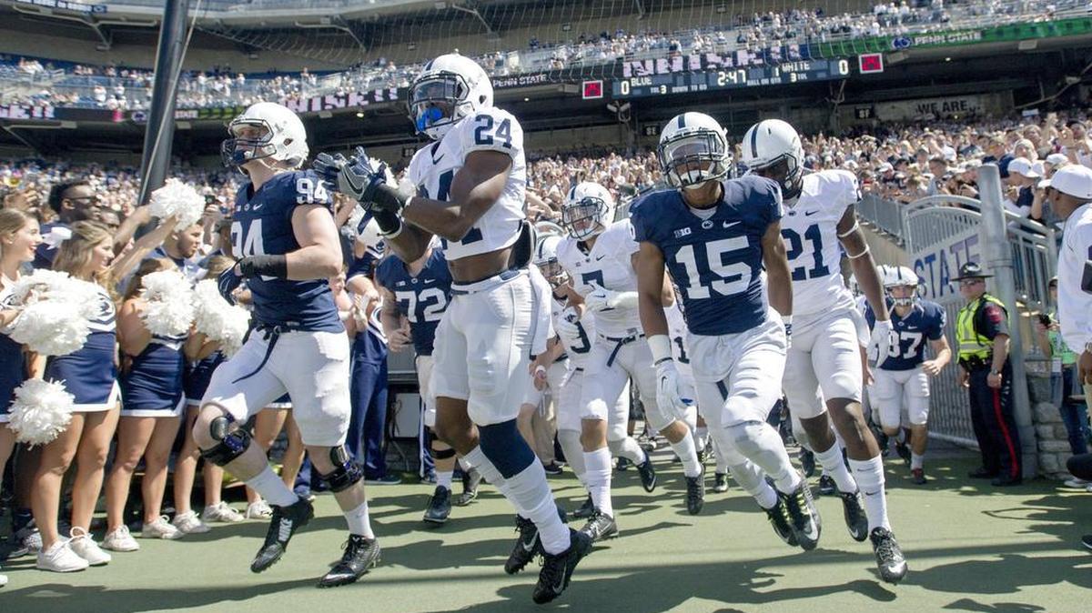 The Penn State football team runs onto the field for the Blue-White game on Saturday, April 16, 2016 at Beaver Stadium.