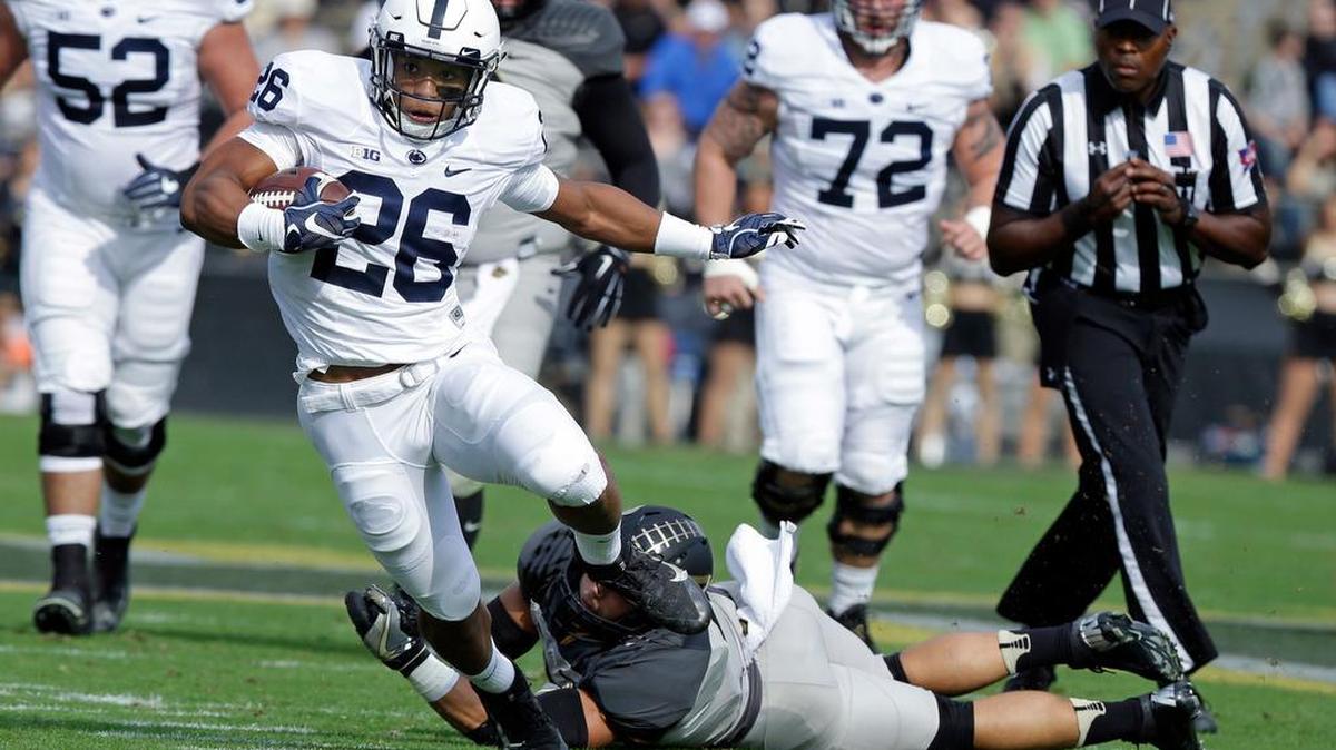 Penn State running back Saquon Barkley (26) runs out of the tackle of Purdue linebacker Markus Bailey (21) during the first half of an NCAA college football game in West Lafayette, Ind., Saturday, Oct. 29, 2016. (AP Photo/Michael Conroy)
