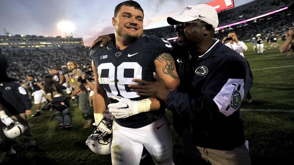 Anthony Zettel, left, gets a hug from defensive line coach Sean Spencer after the 2015 game against San Diego State. One day after his father’s death, Zettel delivered a memorable performance that neither fans nor family would forget.