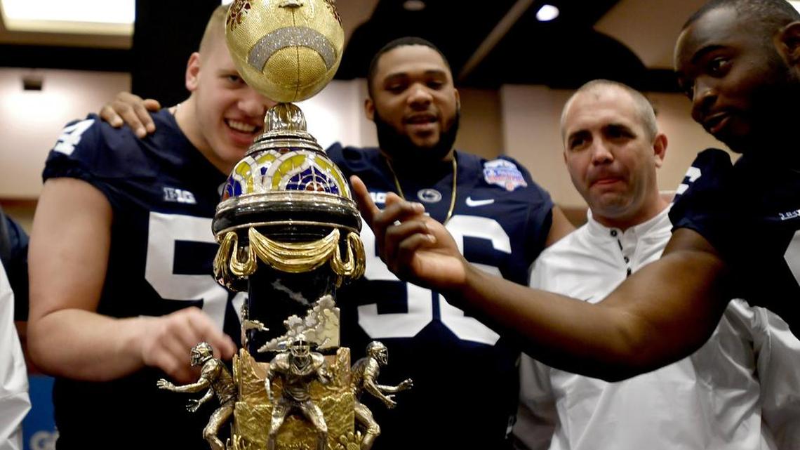 Penn State defensive tackle Robert Windsor and his teammates admire the Fiesta Bowl trophy.