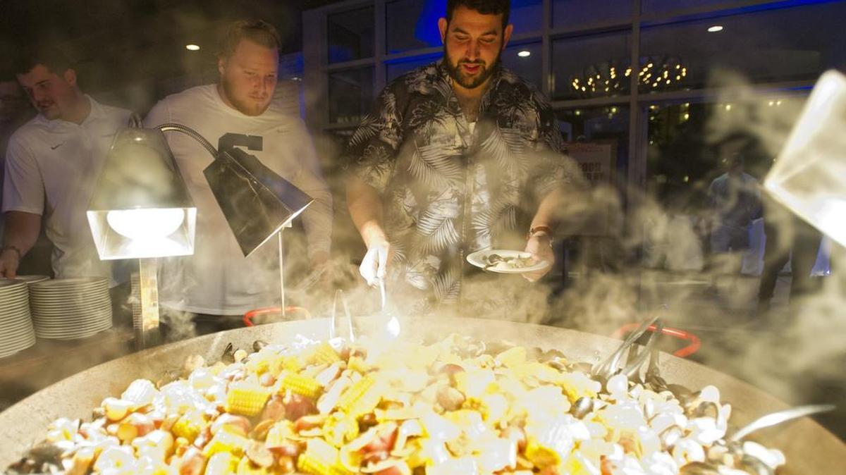 Penn State football's Angelo Mangiro and his teammates dig into a seafood buffet welcoming dinner for the TaxSlayer Bowl at Omni Amelia Island Plantation Resort on Tuesday, December 29, 2015.