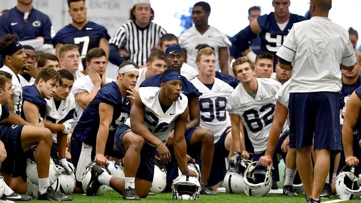 Penn State football quarterback Trace McSorley and running back Saquon Barkley and their teammates listen to coach James Franklin after practice on Wednesday, August 24, 2016 in Holuba Hall.