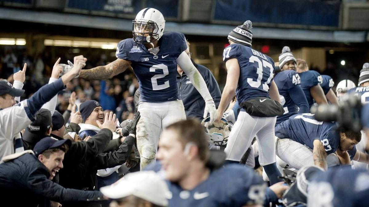 Penn State's Marcus Allen and his teammates climb on the dugouts to high fives fans after the 31-30 overtime win over Boston College in the Saturday, December 27, 2014 Pinstripe Bowl game at Yankee Stadium.