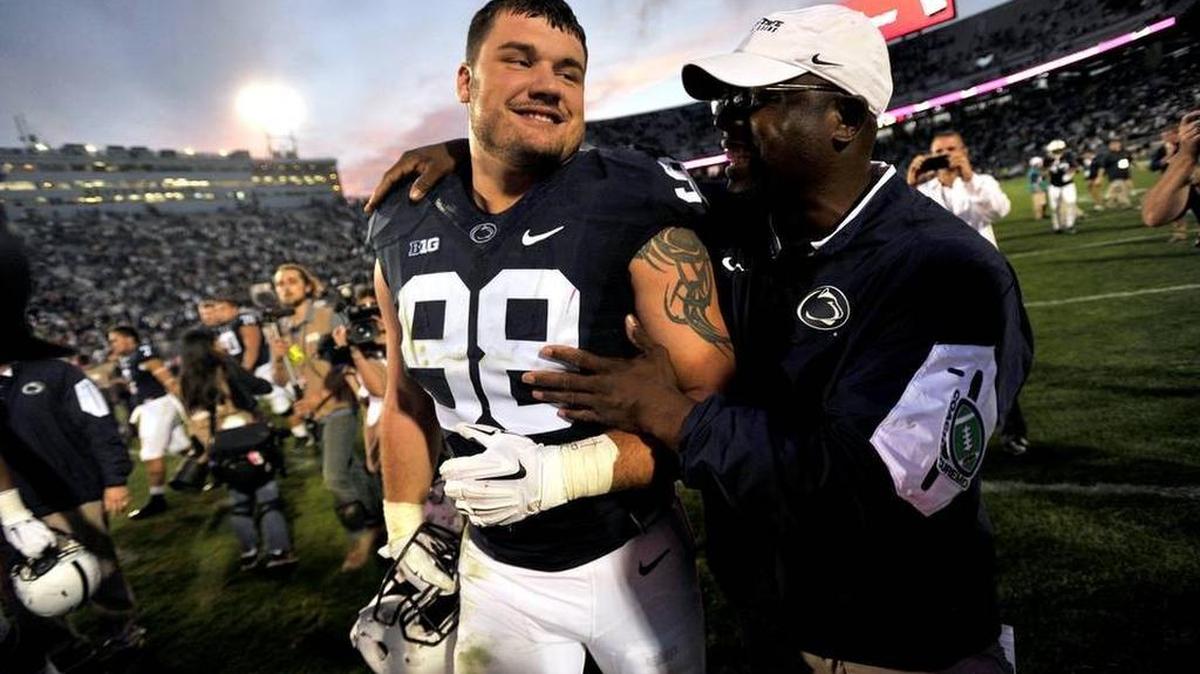 Anthony Zettel, left, gets a hug from defensive line coach Sean Spencer after the game. Penn State plays San Diego State in football Saturday, September 26, 2015 in University Park, Pa. CDT Photo