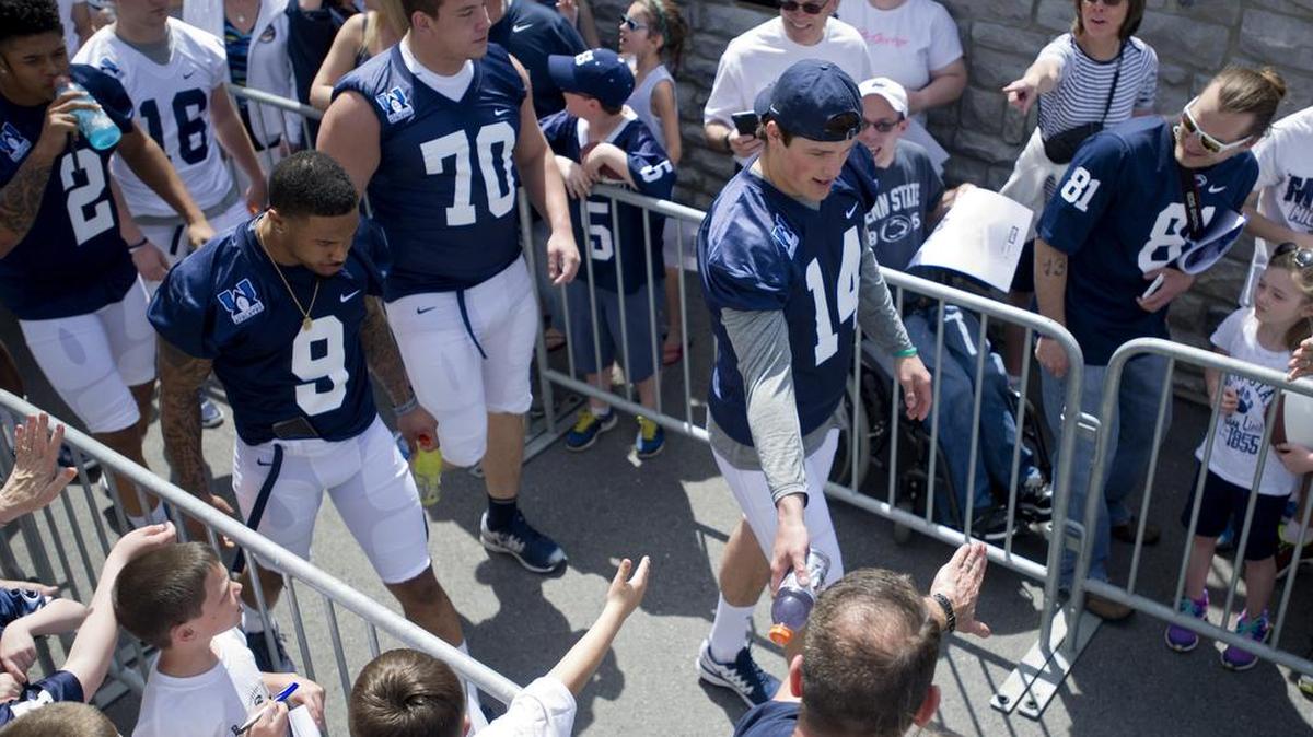 Penn State quarterback Christian Hackenberg high fives fans as he and his teammates walk through the tunnel for the autograph session before the Blue-White game on April 18, 2015 at Beaver Stadium.