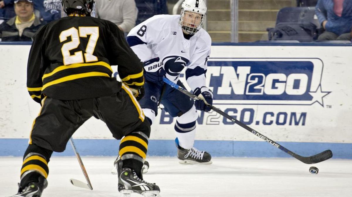 Penn State’s Chase Berger skates with the puck from American International defenders during an October game.
