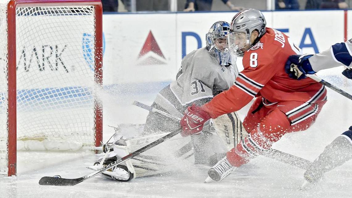 Ohio State's Dakota Joshua knocks the puck in for a goal around Penn State's Peyton Jones during the Saturday, January 21, 2017 at Pegula Ice Arena. Ohio State beat Penn State, 6-3 to sweep the series.