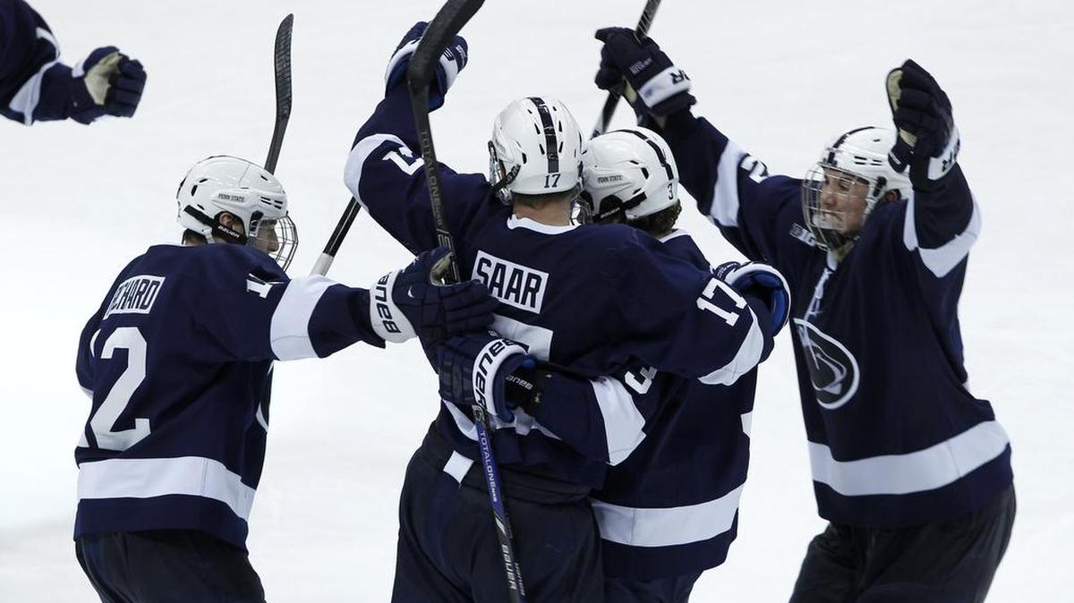 Penn State forward Zach Saar, center, celebrates with teammates after his game-winning shot against Michigan goalie Zach Nagelvoort during the second overtime of an NCAA Big Ten college hockey game in St. Paul, Minn., Thursday, March 20, 2014. Penn State won 2-1.