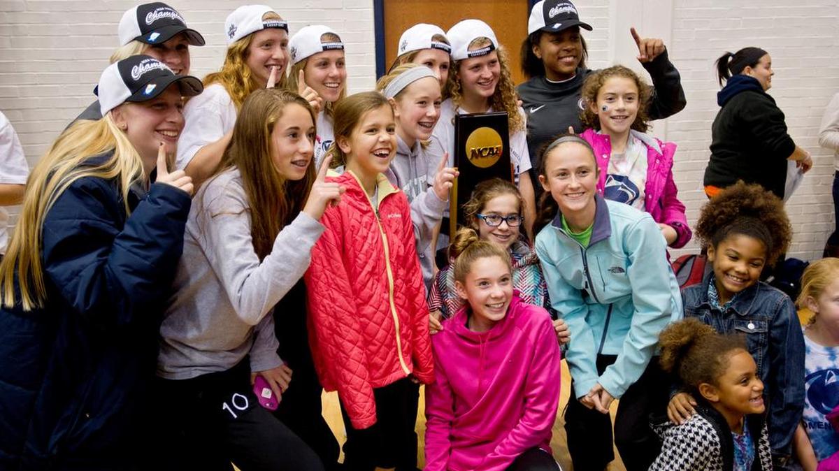 Penn State women’s soccer team poses with their NCAA trophy and young soccer players from the community after being welcomed home on Sunday.