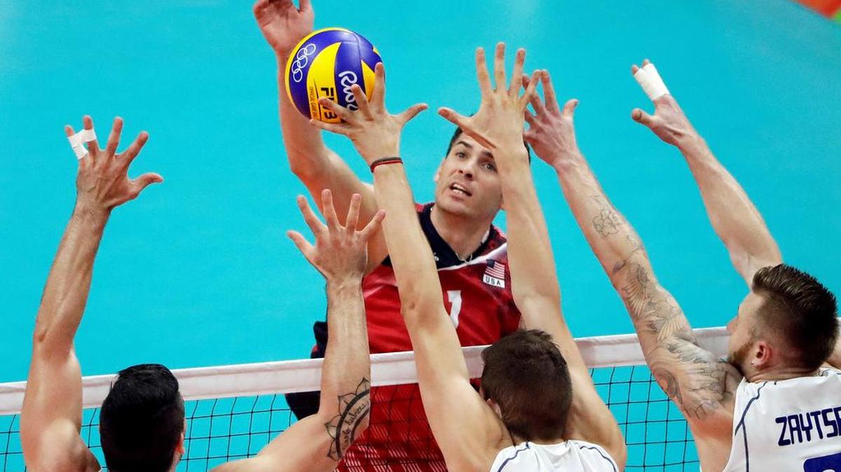 United States' Matt Anderson spikes the ball as Italy's Filippo Lanza, left, Matteo Piano, center, and Ivan Zaytsev block during a men's preliminary volleyball match at the 2016 Summer Olympics in Rio de Janeiro, Brazil, Tuesday, Aug. 9, 2016. (AP Photo/Matt Rourke)