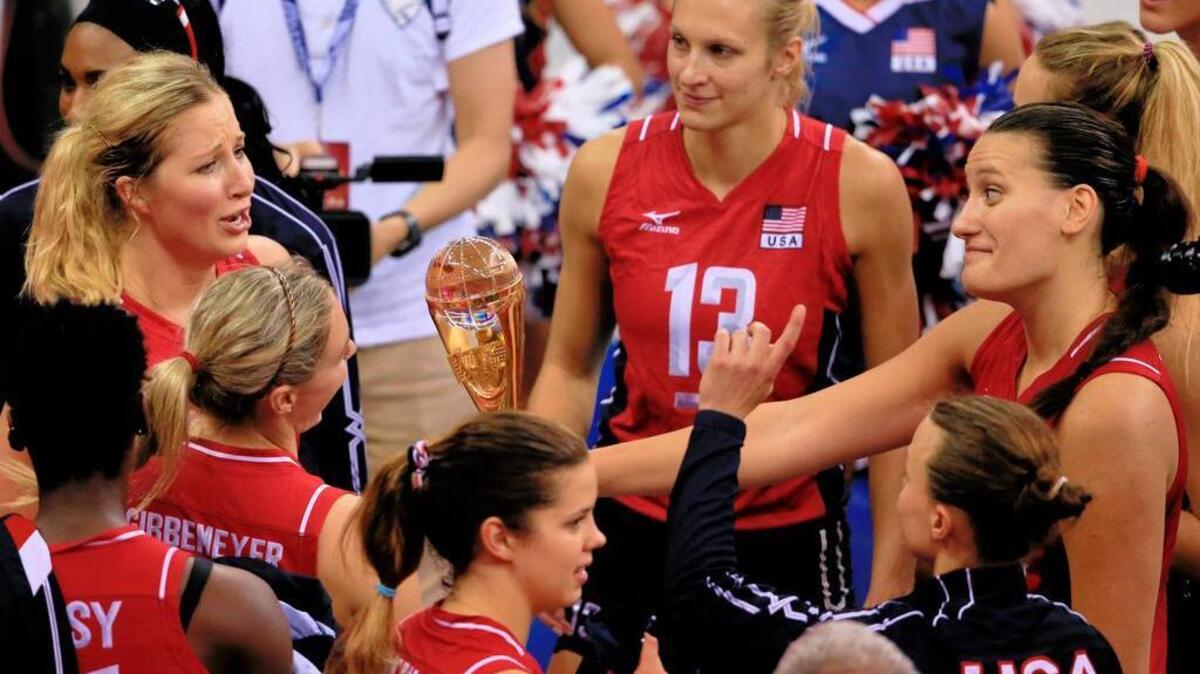United States players Karsta Lowe, left, Tetori Dixon, right, and Christa Harmotto Dietzen, center, admire the championship trophy after their 3-0 win over China and winning the women's FIVB World Grand Prix volleyball championship in Omaha, Neb., Sunday, July 26, 2015.