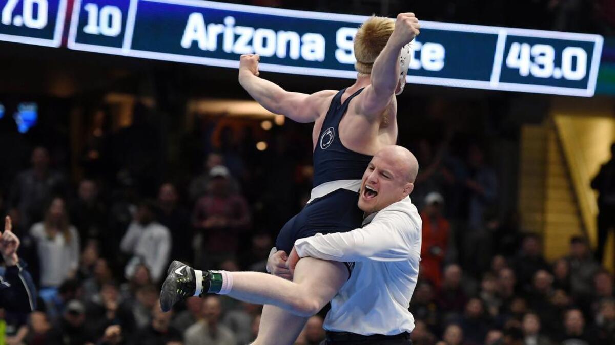 Penn State’s Bo Nickal jumps into head wrestling coach Cael Sanderson’s arms after pinning Ohio State’s Myles Martin in the 184-pound finals during the NCAA Division I Wrestling Championships on Saturday at Quicken Loans Arena in Cleveland.