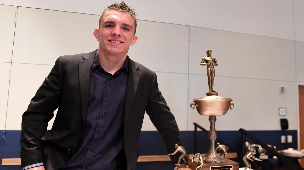 Zain Retherford stands for a portrait next to the Hodge trophy during an awards banquet April 9 at the Penn Stater.