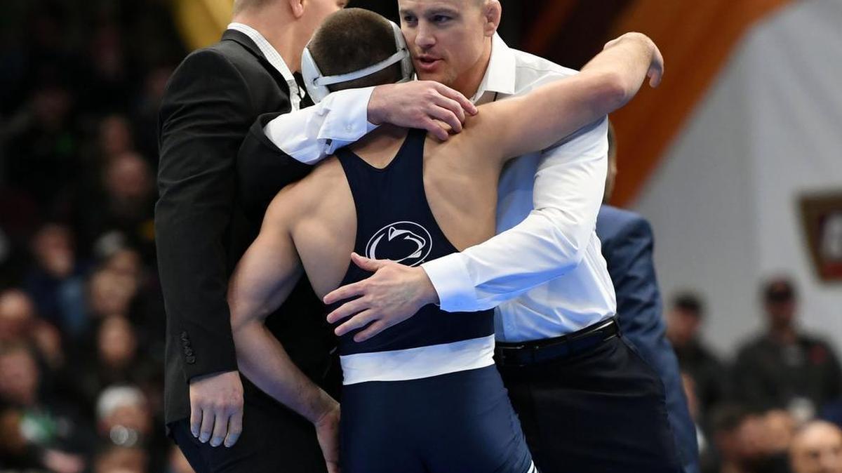 Penn State’s Zain Retherford hugs head wrestling coach Cael Sanderson after his victory in the 149-pound final during the NCAA Division I Wrestling Championships.