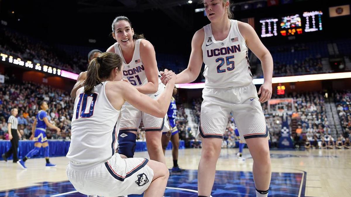 Connecticut’s Natalie Butler and Kyla Irwin, right, help up teammate Molly Bent during Saturday’s game against Tulsa in the American Athletic Conference tournament quarterfinals at Mohegan Sun Arena in Uncasville, Conn.
